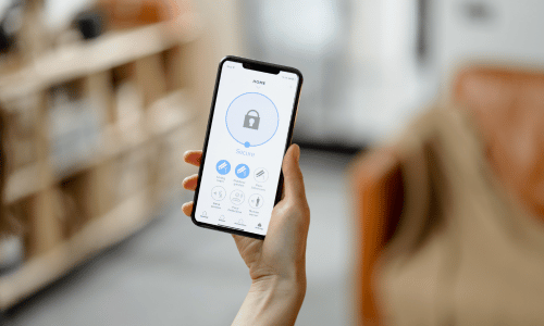 person holding smartphone showing activated burglar alarm system