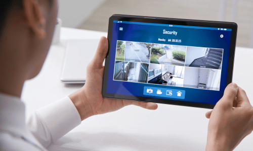 person watching security camera feeds on tablet