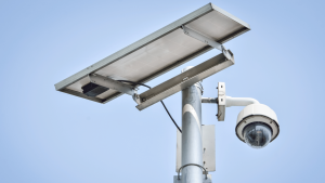 PTZ dome camera and solar panel mounted on pole with sky background