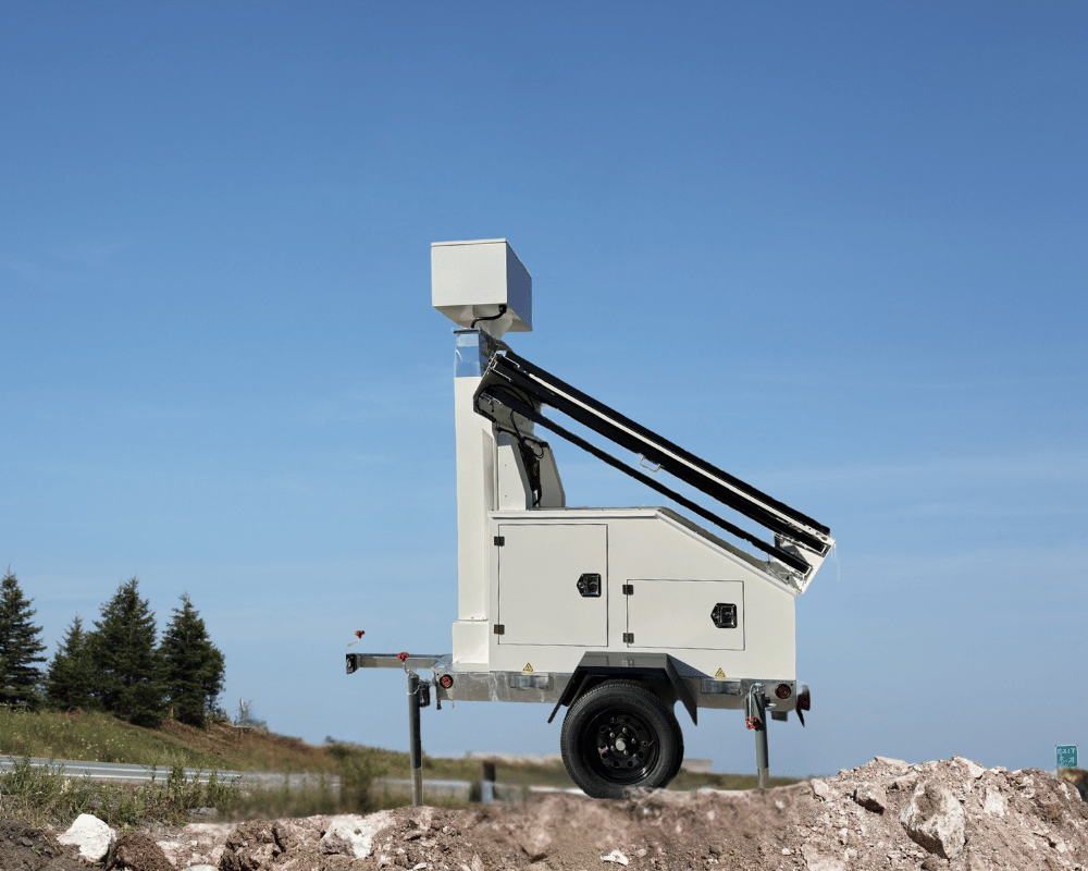 Mobile solar trailer with folded solar panels atop a rocky hill