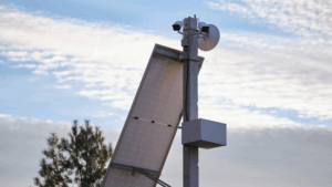 Pole mounted surveillance cameras and loudspeakers with solar panels