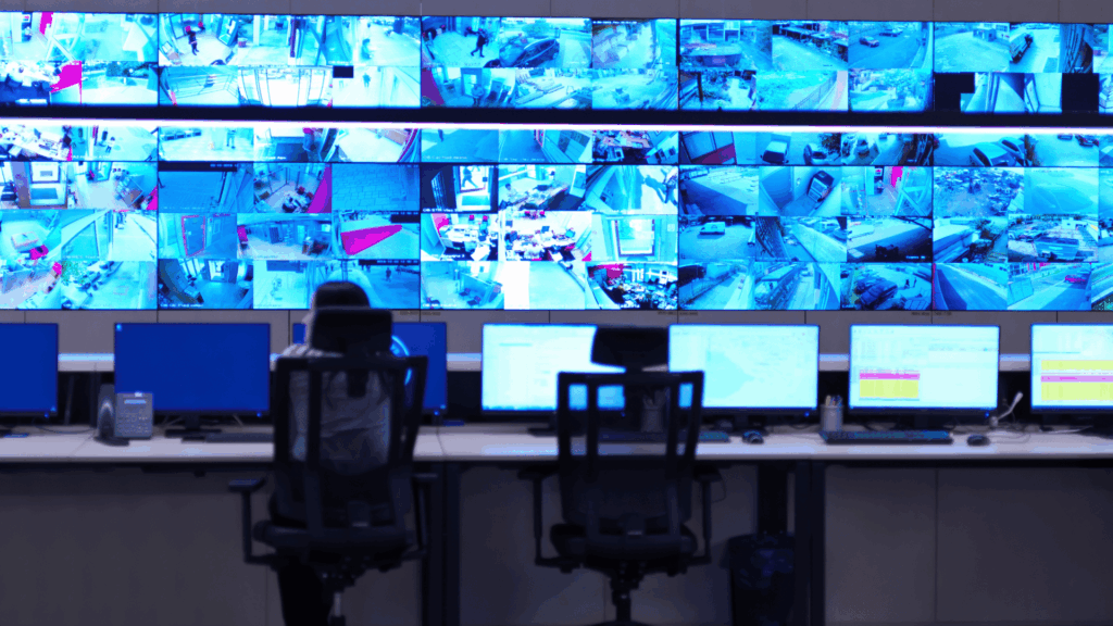 data center security guard monitoring surveillance feeds in control room