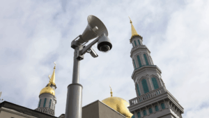 Pole-mounted surveillance camera and loudspeaker system outside a church cathedral
