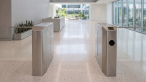 2M Technology 2MWT-5 wing turnstile with integrated HID card readers and Avigilon Access Control Manager (ACM) in commercial office lobby