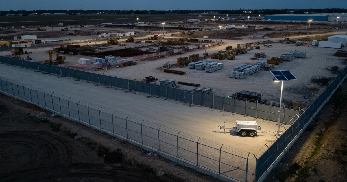 Aerial photograph of construction site with unlit perimeter fence blind spots and distant solar surveillance camera trailer