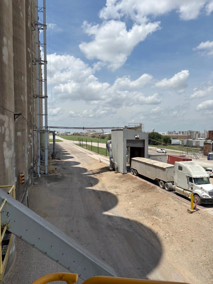 Grain loading trucks on rail tracks at grain silo