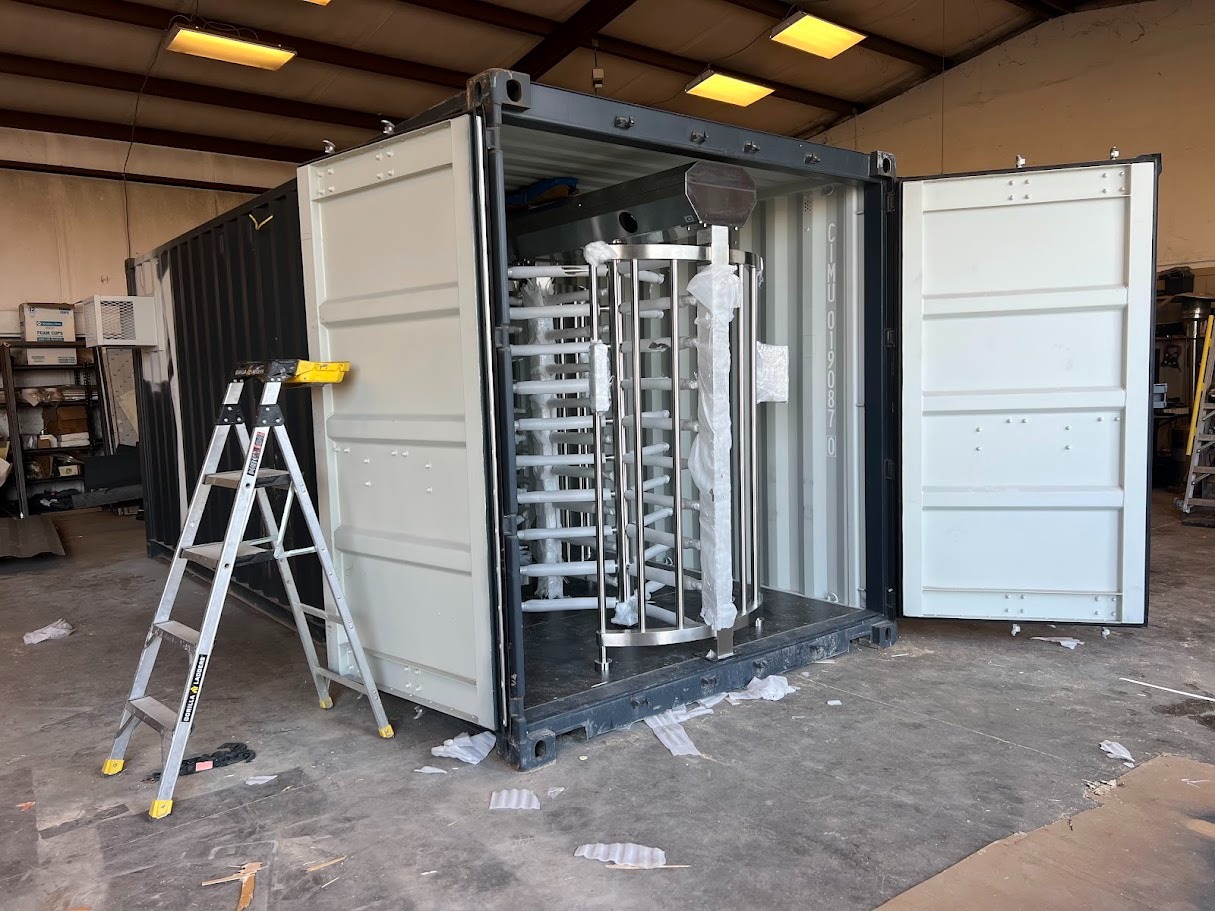 Container security checkpoint fabrication — full-height turnstiles being installed in shipping container Grand Prairie TX
