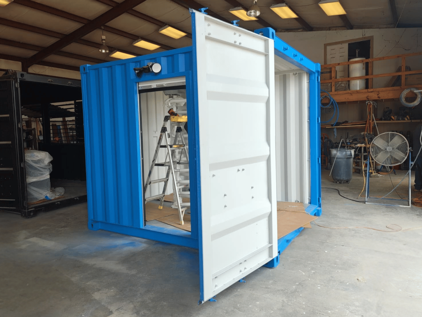 Exterior view of a wrapped full-height turnstile being fitted inside a 10-ft container security checkpoint