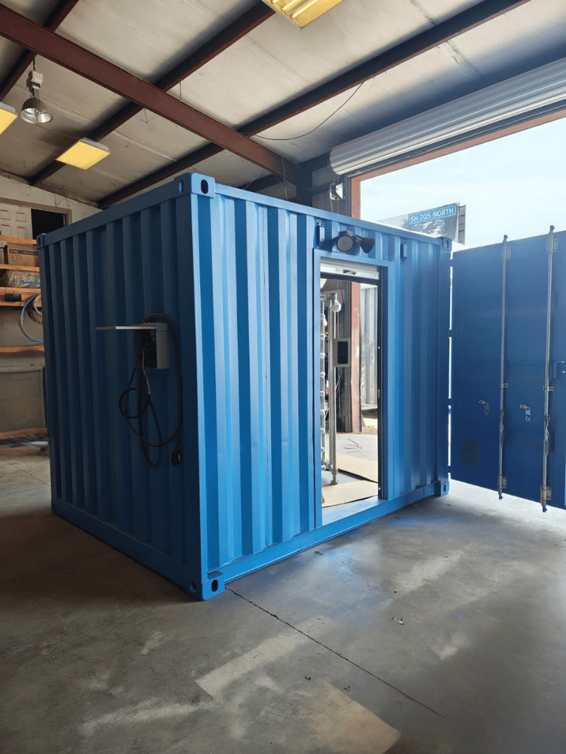 Exterior view of a completed 10-ft container turnstile checkpoint with open pedestrian entrance and side electrical box